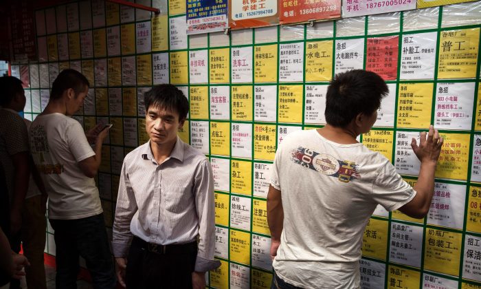 Мужчины смотрят объявления о вакансиях на доске объявлений в центре города Иу в провинции Чжэцзян, Китай, 18 сентября 2015 г. (Кевин Фрайер / Getty Images) | Epoch Times Россия
