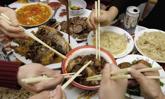 Китайская семья ест новогодний ужин в Пекине, Китай, 8 февраля 2005 г. (China Photos / Getty Images) | Epoch Times Россия