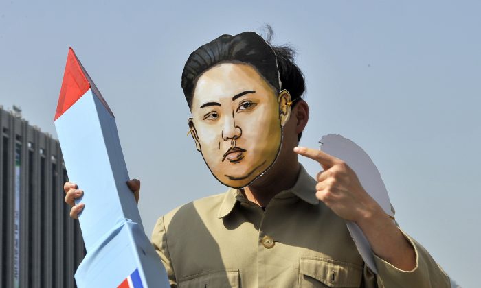 Южнокорейский активист в маске северокорейского лидера Ким Чен Ына держит имитацию ракеты во время митинга, осуждающего запуск ракеты Северной Кореей и диктатуру трех поколений, в Сеуле 15 апреля 2012 г. (JUNG YEON-JE / AFP / Getty Images) | Epoch Times Россия