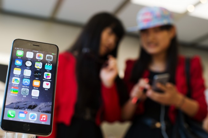 Китайские девушки с iPhone 6 в магазине Apple в Шанхае 17 октября 2015 г. Фото: Johannes Eisele/AFP/Getty Images | Epoch Times Россия