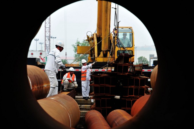 Рабочие на морской нефтяной платформе в Циндао, Китай, 1 июля 2016 г. Фото: STR/AFP/Getty Images | Epoch Times Россия