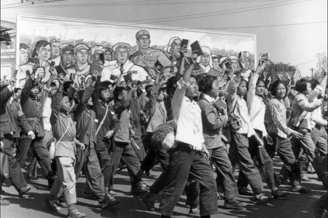 Китайские хунвейбины — ученики средних школ и студенты вузов, размахивая «Красной Книгой» Мао Цзэдуна, идут по улицам Пекина в начале «культурной революции», июнь 1966 г. Во время «культурной революции» в Китае (1966-1976 гг.) под командованием Мао «красные охранники» бесчинствовали в большей части страны, унижали, мучили и убивали «классовых врагов» и уничтожали культурные памятники. Фото: Jean Vincent/AFP/Getty Imagess | Epoch Times Россия