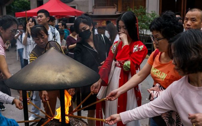 Китайцы поджигают ароматические палочки во время фестиваля середины осени в храме Цзинань в Шанхае, 4 октября 2017 года. Фото: Chandan Khanna/AFP/Getty Images | Epoch Times Россия