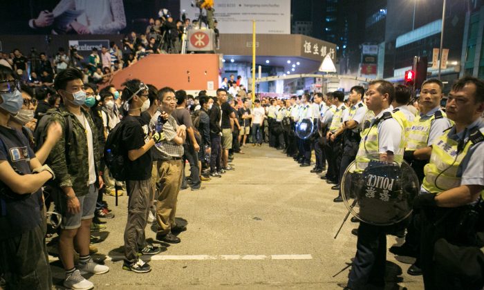 Протестующие, выступающие за демократию, противостоят полиции после того, как они всю ночь пытались отключить части улиц Аргайл и Натан-роуд в Монг-Коке, Гонконг, 18 октября 2014 г. (Бенджамин Честин / Epoch Times) | Epoch Times Россия