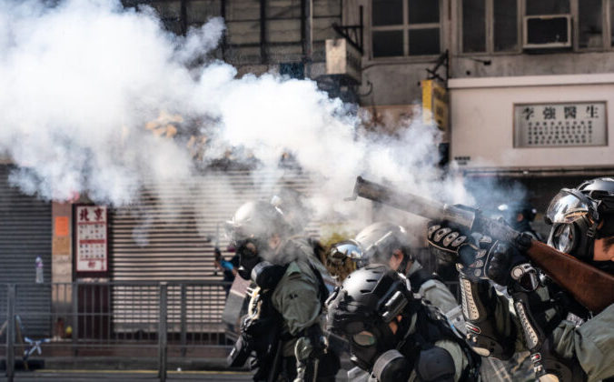 Силовики стреляют слезоточивым газом на улице, чтобы разогнать протестующих в Гонконге, 11 ноября 2019 года. Фото: Anthony Kwan/Getty Images | Epoch Times Россия