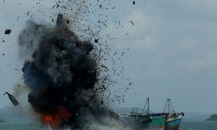 Одно из семи рыболовных судов взорвано правительством Индонезии в Батаме, провинция Кепулауан-Риау, 22 февраля 2016 года. Индонезия уничтожила 23 рыболовных судна после недавнего морского спора с китайскими властями. (Сей Ратифа / AFP / Getty Images) | Epoch Times Россия