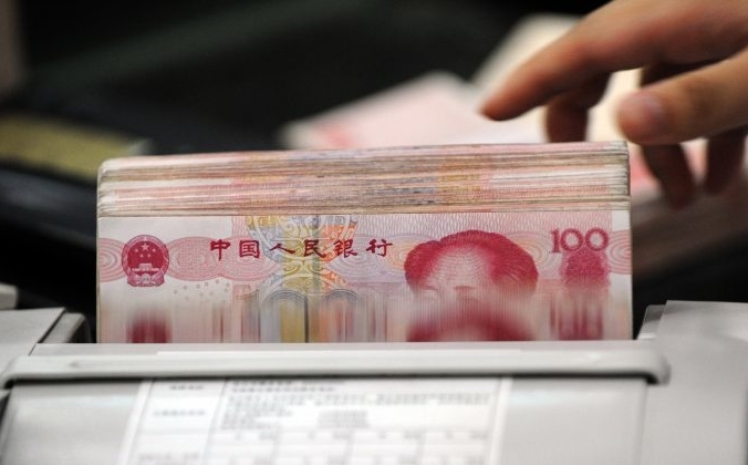 Банковский служащий подсчитывает пачки банкнот в 100 юаней в банке в Хэфэй, провинция Аньхой, Китай, 14 октября 2010 года. STR / AFP / Getty Images | Epoch Times Россия