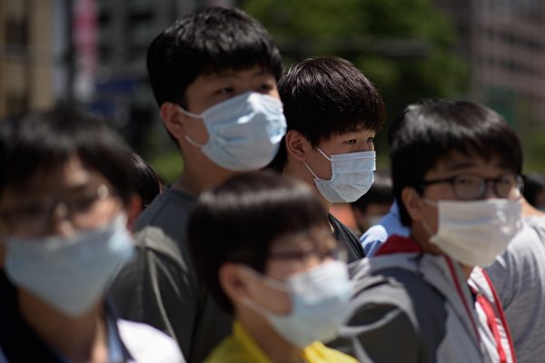 Ученики в масках собираются перейти через дорогу, Сеул, Южная Корея ED JONES/AFP/Getty Images | Epoch Times Россия