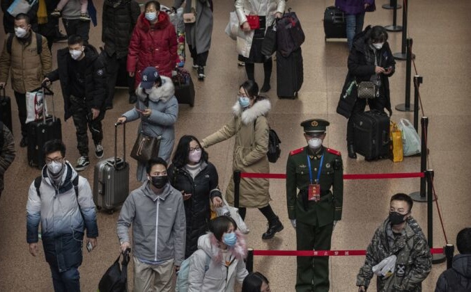 Пассажиры и полицейский в масках на железнодорожном вокзале в Пекине. Kevin Frayer/Getty Images | Epoch Times Россия