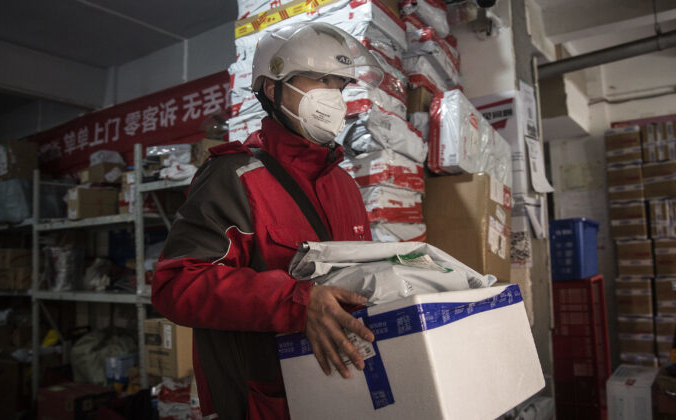 Сотрудник по доставке на экспресс-станции в Ухане, провинция Хубэй, Китай, 20 января 2020 года. Stringer / Getty Images | Epoch Times Россия