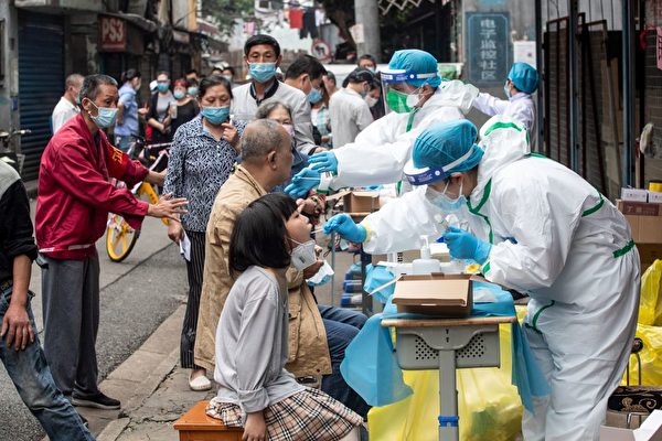 Медицинские работники берут образцы у жителей, чтобы проверить их на наличие коронавируса COVID-19, на улицах Уханя, провинция Хубэй, Китай, 15 мая 2020 года. STR/AFP via Getty Images | Epoch Times Россия