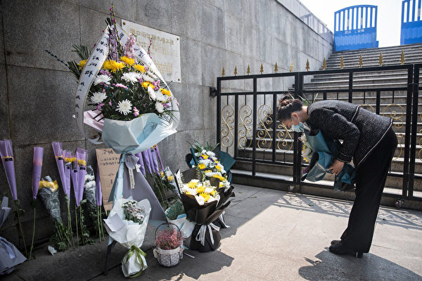 Жительница Уханя преподносит цветы в память погибших во время вспышки COVID-19, 4 апреля 2020 года. Getty Images | Epoch Times Россия