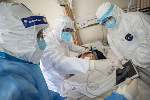 Врач смотрит на изображение, во время обследования пациента с COVID-19, в больнице Уханьского общества Красного Креста 16 февраля 2020 года. STR/AFP via Getty Images | Epoch Times Россия