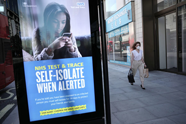 Женщина проходит мимо рекламы NHS Test and Trace на Оксфорд-стрит, где магазины вновь открываются после  вспышки COVID-19, Лондон, Великобритания, 15 июня 2020 года. Dan Kitwood/Getty Images | Epoch Times Россия