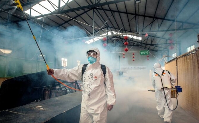 Персонал распыляет дезинфицирующее средство на рынке в Суйфэньхэ, Хэйлунцзян, Китай 6 мая 2020 года.  STR/AFP через Getty Images | Epoch Times Россия