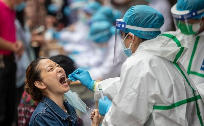 Медицинский работник берёт образец у местного жителя для тестирования на COVID-19  в Ухане, Китай, 15 мая 2020 года. STR / AFP via Getty Images | Epoch Times Россия