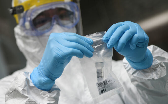 Медицинский работник собирает образцы для тестирования COVID-19 в средней школе в Гуанчжоу, Китай, 21 апреля 2020 года. STR/AFP via Getty Images | Epoch Times Россия