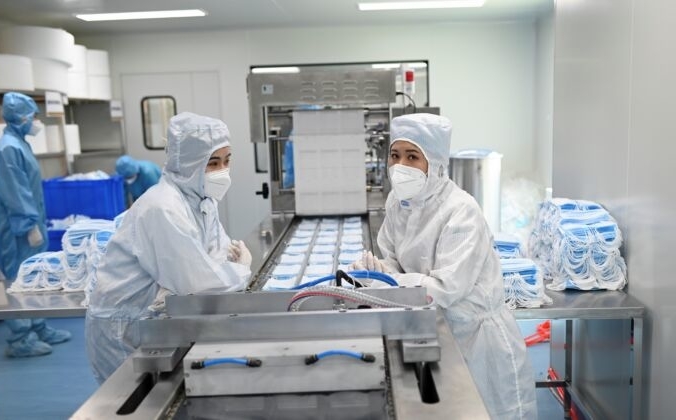 Две работницы готовятся к упаковке масок в  помещении Naton Medical Group в Пекине, Китай, 24 апреля 2020 года. WANG ZHAO/AFP via Getty Images | Epoch Times Россия