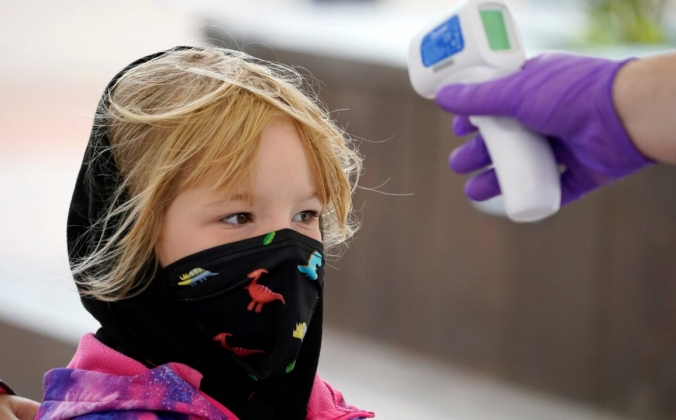 Ребёнку в маске проверяют температуру возле входа в парк Alton Towers в Альтоне, Англия, 4 июля 2020 года. Christopher Furlong/Getty Images | Epoch Times Россия