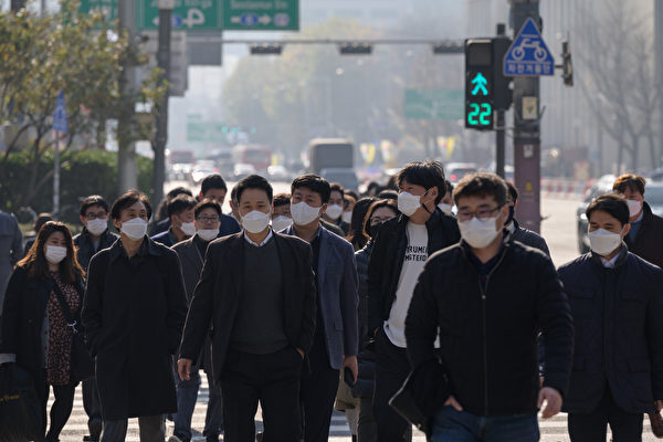 Пешеходы в масках переходят улицу в Сеуле 26 ноября 2020 года. ED JONES/AFP via Getty Images | Epoch Times Россия