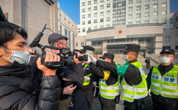 Полиция пытается помешать журналистам вести съёмку у здания Народного суда района Пудун в Шанхае 28 декабря 2020 года. Leo Ramirez/AFP via Getty Images | Epoch Times Россия