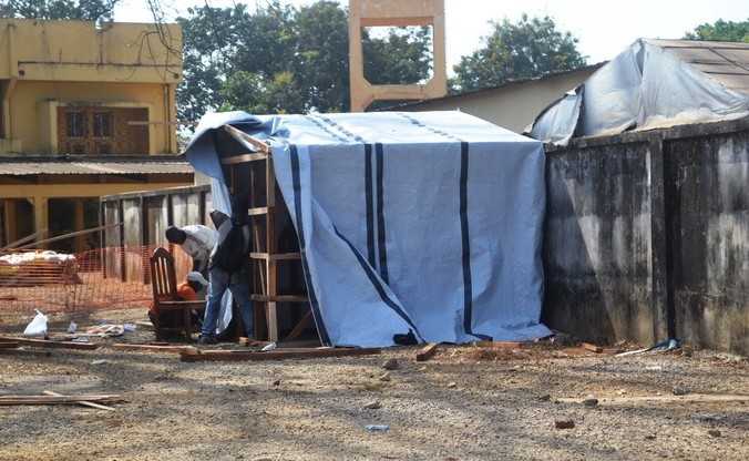 Рабочие сооружают палатку в изолированной зоне, где есть пациенты с подозрением на лихорадку Эбола. Несколько случаев  заболевания смертельно опасной лихорадкой Эбола зафиксированы в столице Гвинеи Конакри 29 марта 2014 года. Фото: CELLOU BINANI/AFP/Getty Images | Epoch Times Россия