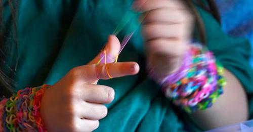 Руки Хейли Орлински быстро двигаются, когда она создает браслет из разноцветных резинок в среду, 2 декабря 2020 года, в спальне своего дома в Чикаго. (AP Photo / Чарльз Рекс Арбогаст) | Epoch Times Россия