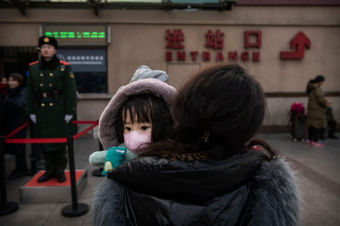 Девочка в маске на центральном вокзале Пекина. Kevin Frayer/Getty Images | Epoch Times Россия
