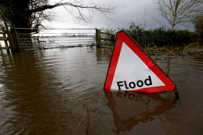 Затопленная табличка с надписью «Наводнение». Фото:  Matt Cardy/Getty Images | Epoch Times Россия