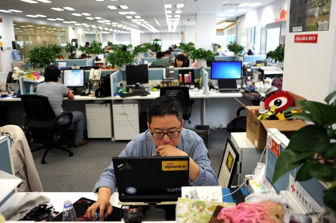 Человек сидит за ноутбуком в офисе Sina Weibo, который называют китайским аналогом Твиттера, Пекин, 16 апреля 2014 года. Фото: Wang Zhao/AFP/Getty Images | Epoch Times Россия