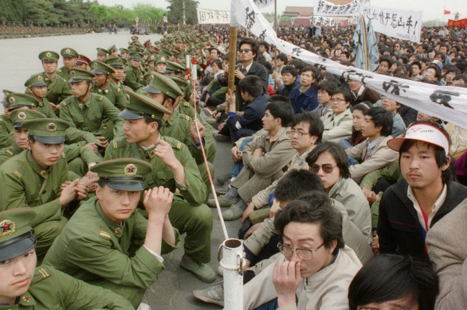 Несколько сот патриотично настроенных студентов сидят рядом с полицейскими у Дома народных собраний на площади Тяньаньмэнь в Пекине 22 апреля 1989 г. Фото: Catherine Henriette/AFP/Getty Images | Epoch Times Россия