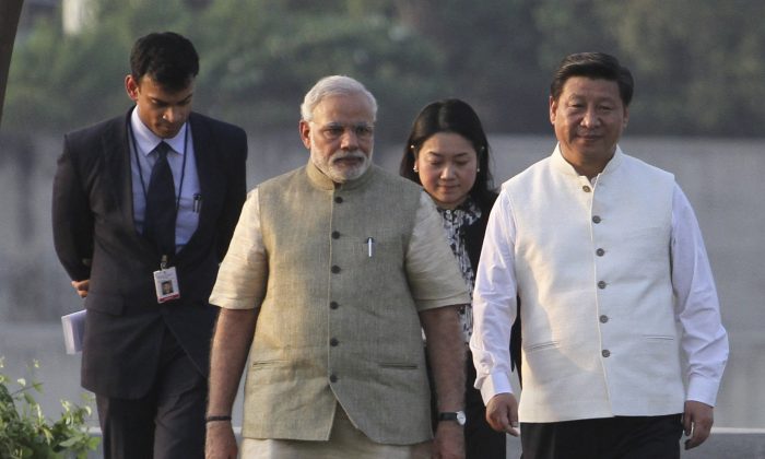 Премьер-министр Индии Нарендра Моди (2-й слева) и лидер Коммунистической партии Китая Си Цзиньпин (справа) идут по набережной реки Сабармати в Ахмадабаде, Индия, 17 сентября 2014 года. Си находится с трехдневным визитом, целью которого является улучшение отношений и инвестиции с Индией. (AP Photo / Аджит Соланки) | Epoch Times Россия