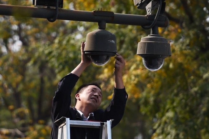 Рабочий настраивает камеры наблюдения на площади Тяньаньмэнь в Пекине 30 сентября 2014 года. Фото: GREG BAKER/AFP/Getty Images | Epoch Times Россия