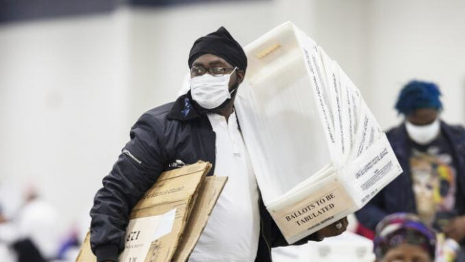 Сотрудник Департамента выборов Детройта несет пустые ящики для бюллетеней, после того, как почти завершился подсчёт бюллетеней, отправленных по почте в Детройте, штат Мичиган, 4 ноября 2020 года. Elaine Cromie/Getty Images | Epoch Times Россия