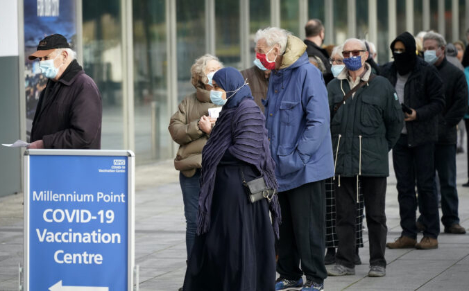 Люди стоят в очереди возле центра массовой вакцинации Национальной службы здравоохранения в Бирмингеме, Великобритания, 11 января 2021 г. (Christopher Furlong / Getty Images) | Epoch Times Россия