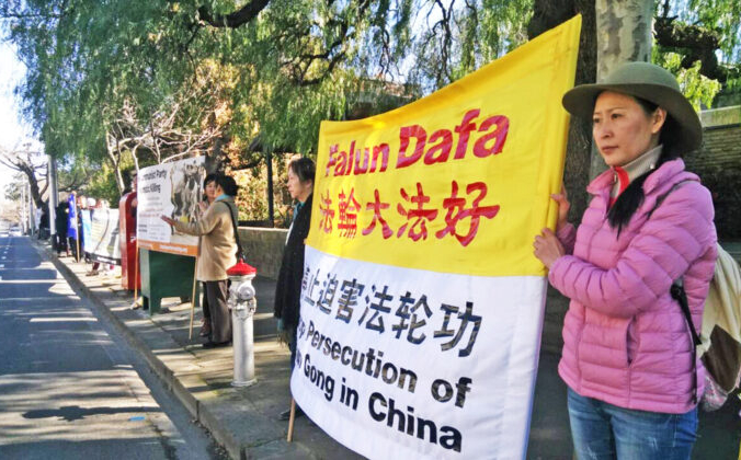 Энджел держит плакат «Прекратите преследование Фалуньгун» напротив главного входа китайского консульства в Тураке в Мельбурне, Австралия. (Фото предоставлено Энджел) | Epoch Times Россия