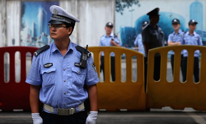 Китайские полицейские охраняют здание народного суда промежуточной инстанции Цзинань, 25 августа 2013 года в Цзинане, Китай. (Фэн Ли / Getty Images) | Epoch Times Россия