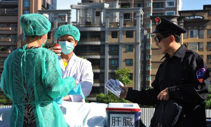 Последователи Фалуньгун разыгрывают сцену кражи человеческих органов для продажи во время демонстрации в Тайбэе 20 июля 2014 г. (Мэнди Ченг / AFP / Getty Images) | Epoch Times Россия