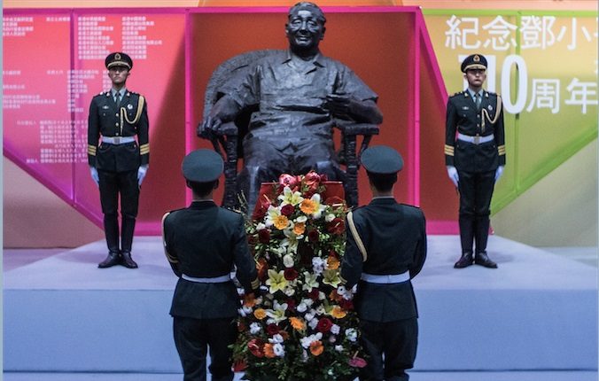 Китайские солдаты несут цветы к скульптуре бывшего китайского лидера Дэн Сяопина в честь его 110-летия, 21 августа, Гонконг. Фото: Lam Yik Fei/Getty Images | Epoch Times Россия
