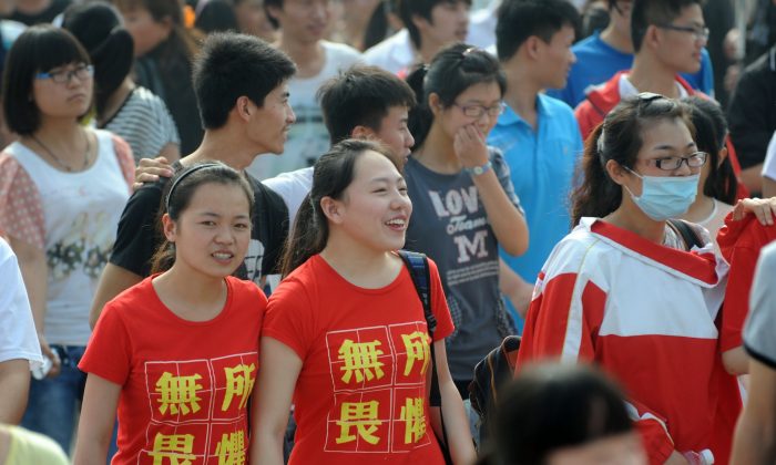 Две студентки носят футболки с надписью «ничего не бойтесь» перед входом в экзаменационную комнату для вступительных экзаменов в колледж в Китае, или «гаокао», в Бочжоу, провинция Аньхой на востоке Китая, 7 июня 2014 г. (AFP / AFP / Getty Images) | Epoch Times Россия