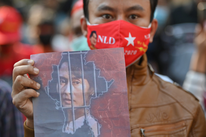 Мьянмский мигрант держит изображение Аун Сан Су Чжи во время демонстрации у посольства Мьянмы в Бангкоке 1 февраля 2021 года. Lillian Suwanrumpha/AFP via Getty Images | Epoch Times Россия
