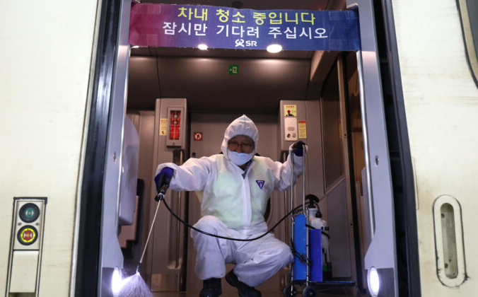 Работник в защитном костюме распыляет антисептическое средство в поезде на фоне опасений по поводу распространения нового коронавируса 2019 года, также известного как уханьская пневмония, Сеул, Южная Корея, 24 января 2020 года. Chung Sung-Jun/Getty Images | Epoch Times Россия