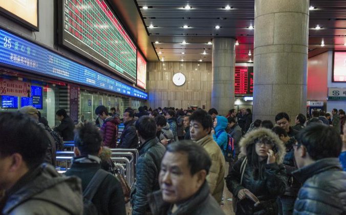 Китайские туристы стоят в очереди за билетом на вокзале Пекина, чтобы попасть домой на празднование китайского Нового года. 4 февраля 2015 года. Фото: Fred Dufour/AFP/Getty Images | Epoch Times Россия