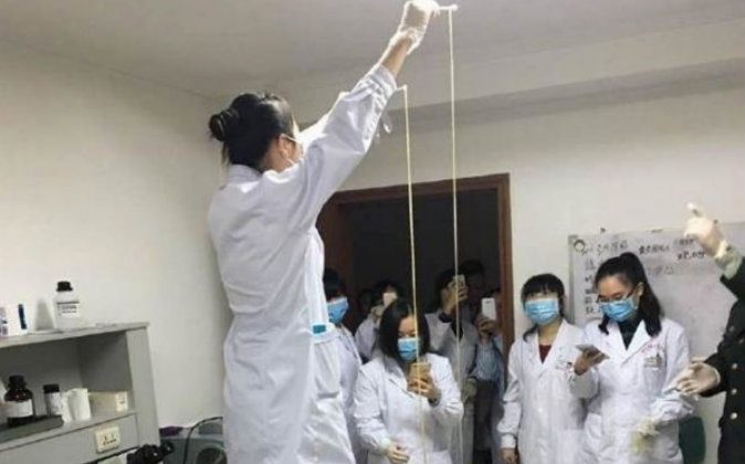 Врач задерживает ленточного червя перед медицинским персоналом. (через China Times News) | Epoch Times Россия
