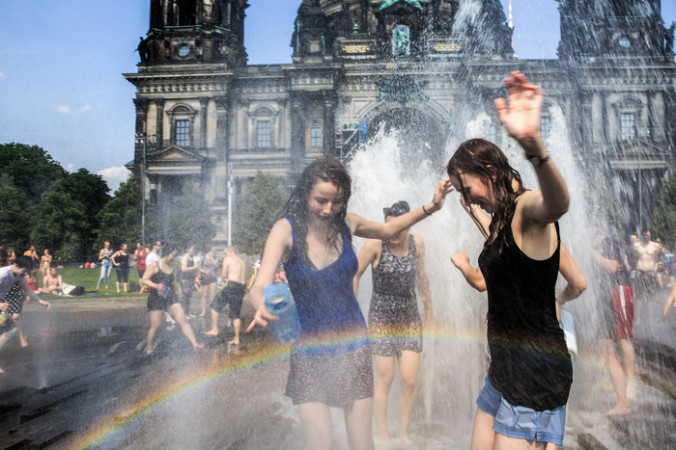 4 июля. Люди освежаются водой в фонтане парка Люстгартен в Берлине, Германия. Температура воздуха в столице 4 июля достигла 37 градусов по Цельсию, этот день стал самым жарким в году. Жара ожидается на этой неделе в большей части Европы. Фото: Carsten Koall/Getty Images | Epoch Times Россия