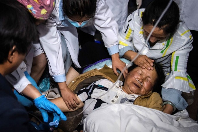 Медицинские работники оказывают помощь женщине после сильного землетрясения в автономном округе Янби И в юго-западной китайской провинции Юньнань 22 мая 2021 года. Hu Chao/Xinhua via AP | Epoch Times Россия