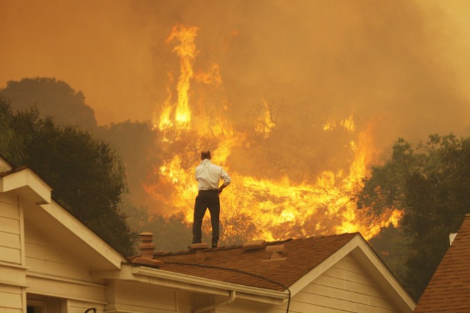 Житель дома смотрит на приближающийся пожар. Фото: David McNew/Getty Images | Epoch Times Россия