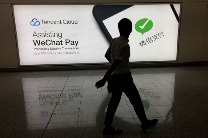 Мужчина проходит мимо рекламы – платформы WeChat для социальных сетей, принадлежащей китайской компании Tencent, в международном аэропорту Гонконга 21 августа 2017 г. (Ричард А. Брукс / AFP / Getty Images) | Epoch Times Россия