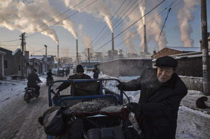 Дым из труб загрязняет воздух. Китайцы тянут тележку в районе угольной электростанции в Шаньси, Китай, 26 ноября 2015 года. (Kevin Frayer/Getty Images) | Epoch Times Россия