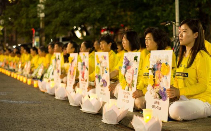 Последователи Фалуньгун проводят медитацию со свечами перед китайским консульством в Торонто 13 июля 2019 года. Они держат портреты практикующих, погибших от преследования в Китае. (Epoch Times) | Epoch Times Россия